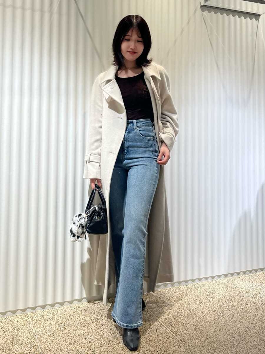 ホワイト系のチェスターコート、ブラウン系のTシャツ/カットソー、ブルー系のその他パンツを着用したレディースの秋コーディネートの2枚目の写真