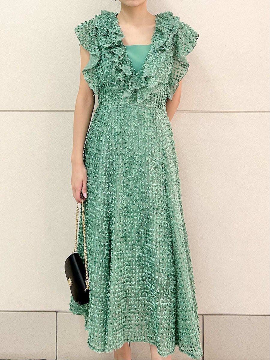 グリーン系のドレス、ブラック系のパンプス、ブラック系のショルダーバッグを着用したレディースの春コーディネートの5枚目の写真