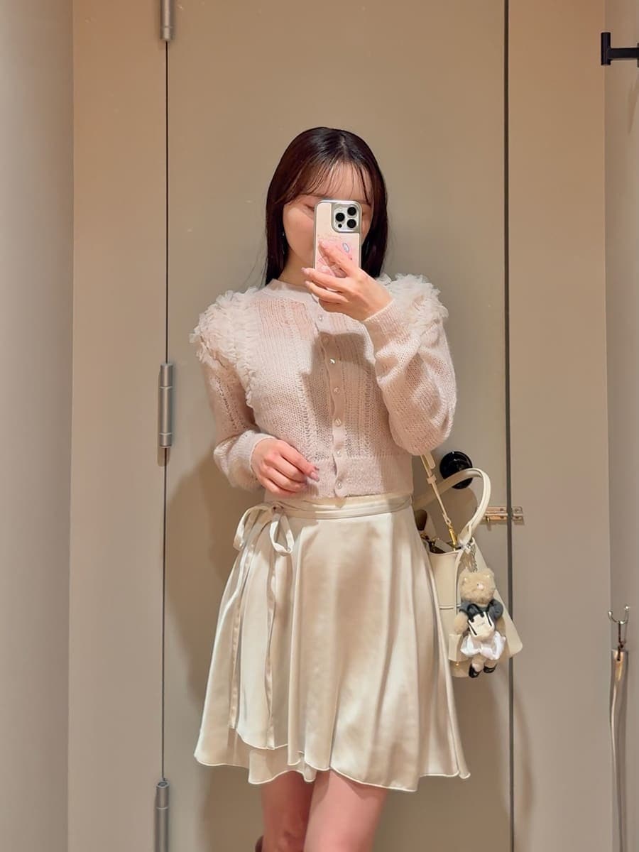 ホワイト系のその他パンツ、ピンク系のカーディガン/ボレロ、ホワイト系のブーツを着用したレディースの冬コーディネートの5枚目の写真