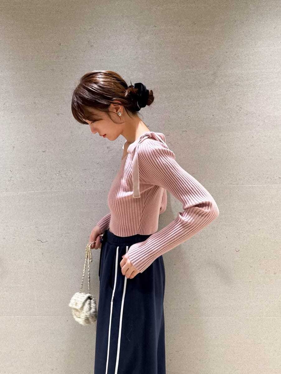 ピンク系のニット/セーター、ホワイト系のショルダーバッグ、レッド系のイヤリングを着用したレディースの夏コーディネートの5枚目の写真