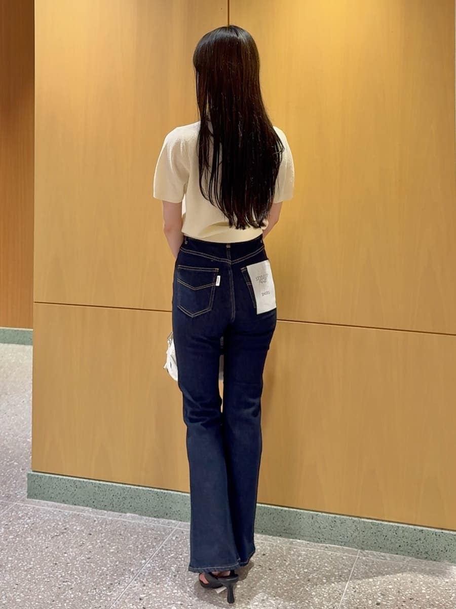 ブルー系のデニムパンツ、ホワイト系のショルダーバッグを着用したレディースの春コーディネートの3枚目の写真