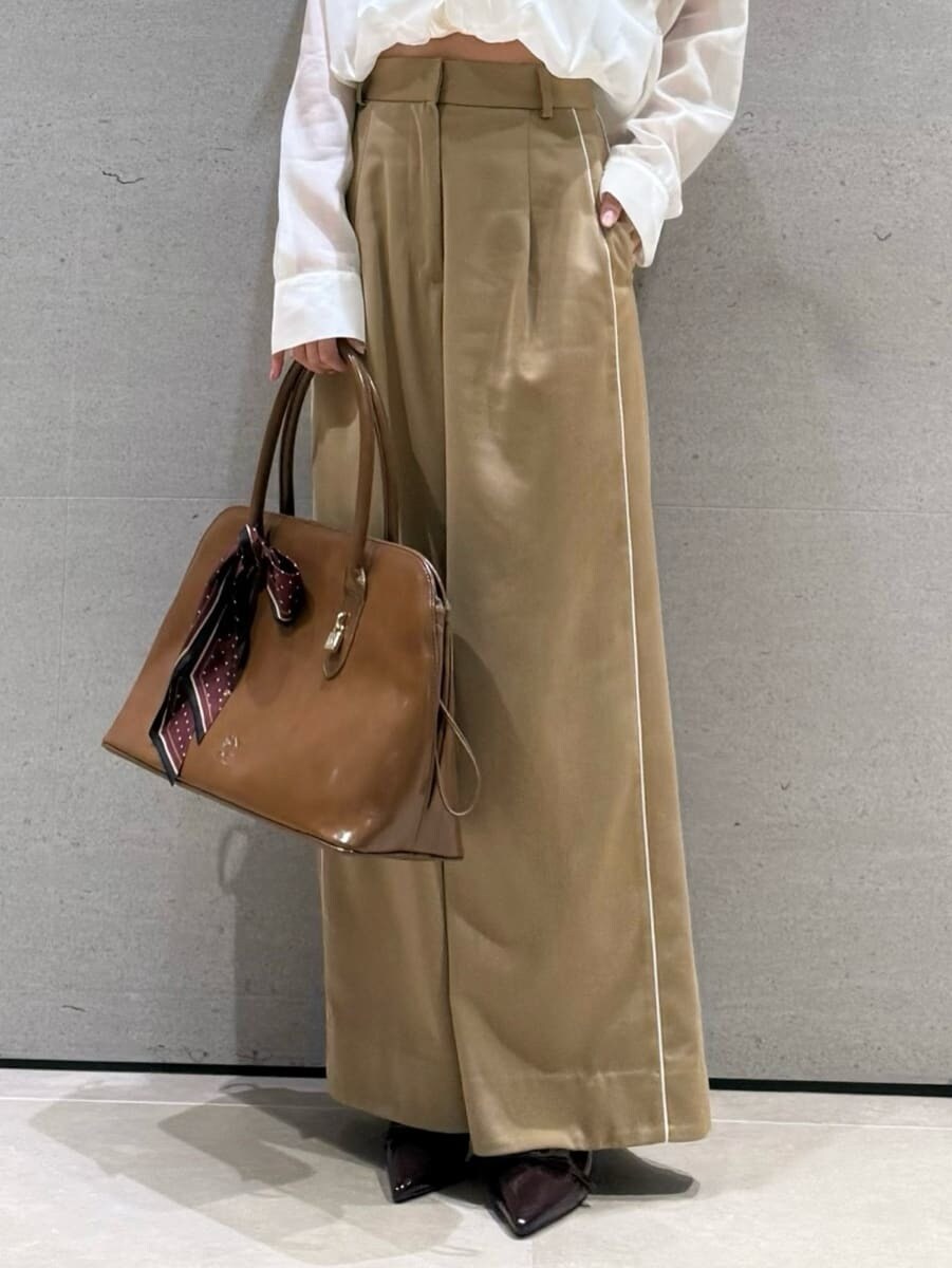 ベージュ系のその他パンツ、ホワイト系のニット/セーター、ブラウン系のハンドバッグを着用したレディースの秋コーディネートの5枚目の写真