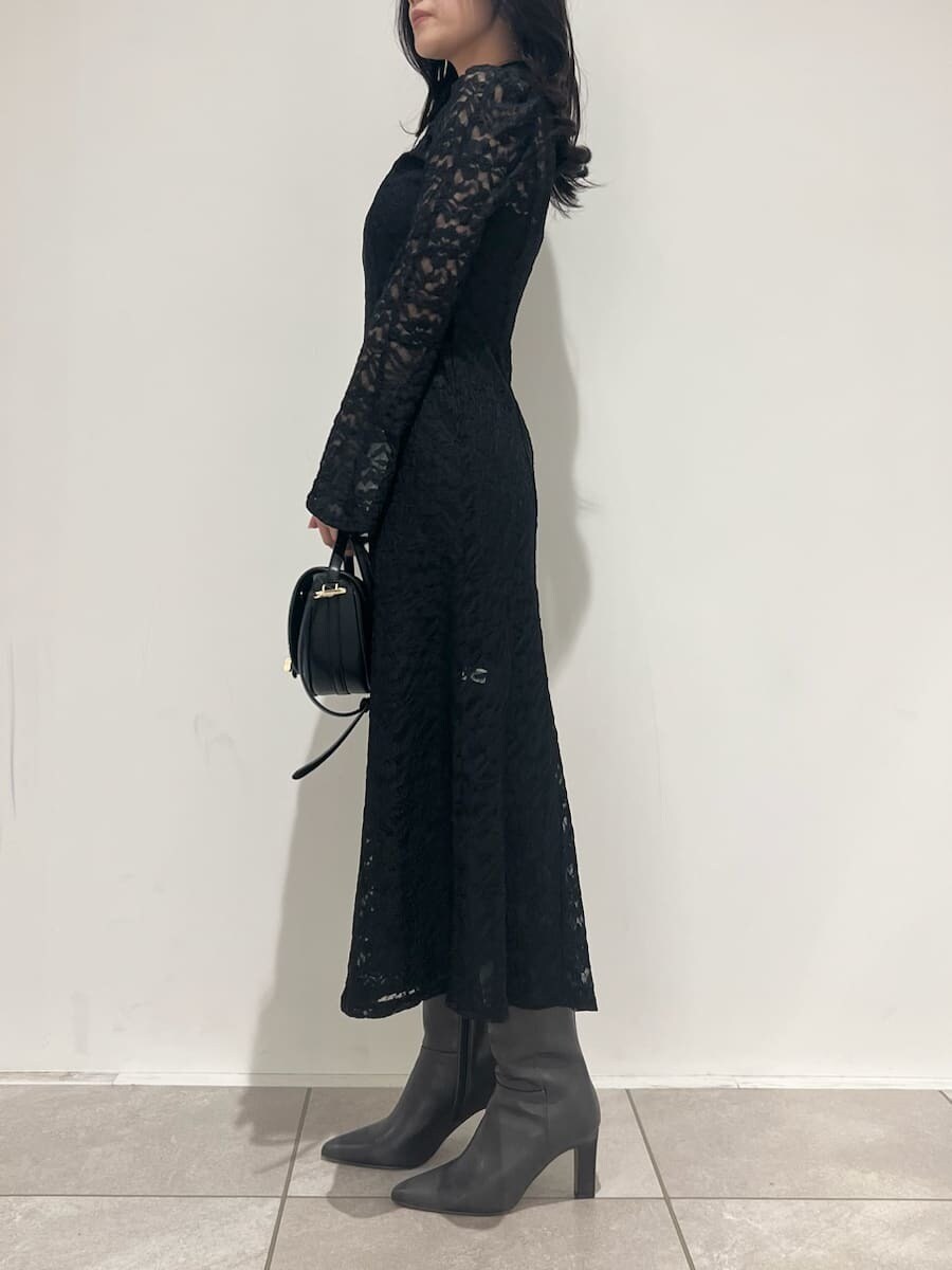 ブラック系のブーツ、ブラック系のハンドバッグ、ブラック系のワンピースを着用したレディースの冬コーディネートの2枚目の写真