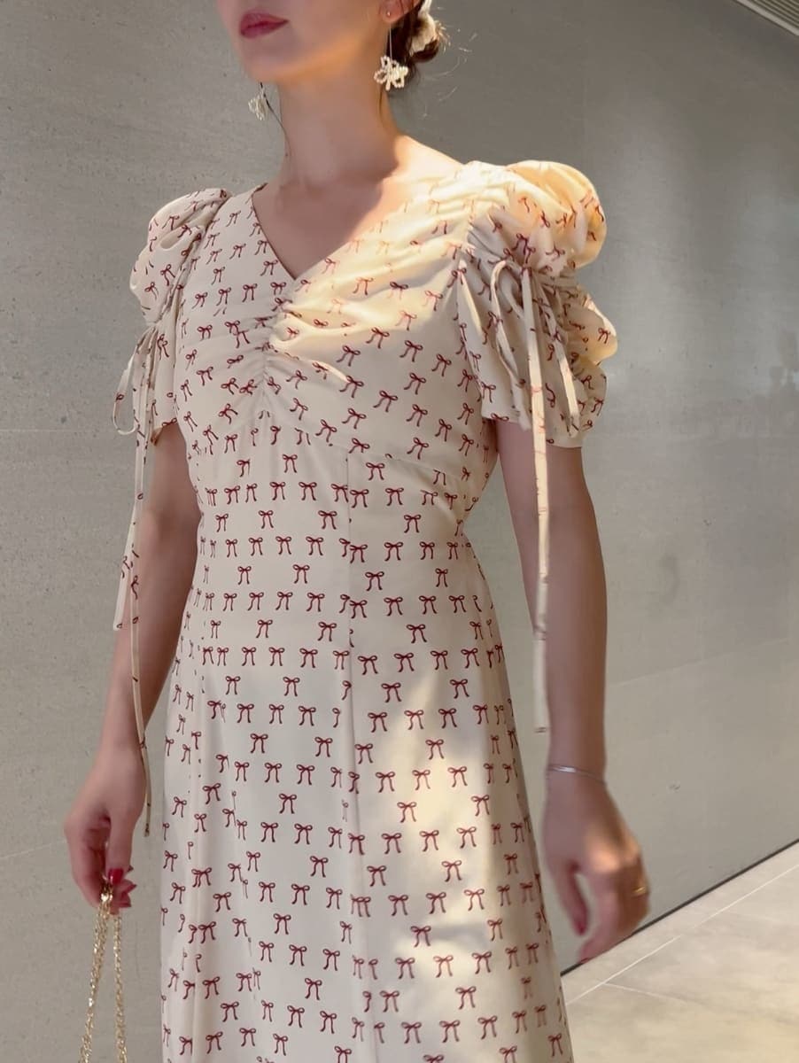 ホワイト系のトレンチコート、ベージュ系のワンピース、ホワイト系のショルダーバッグを着用したレディースの冬コーディネートの9枚目の写真