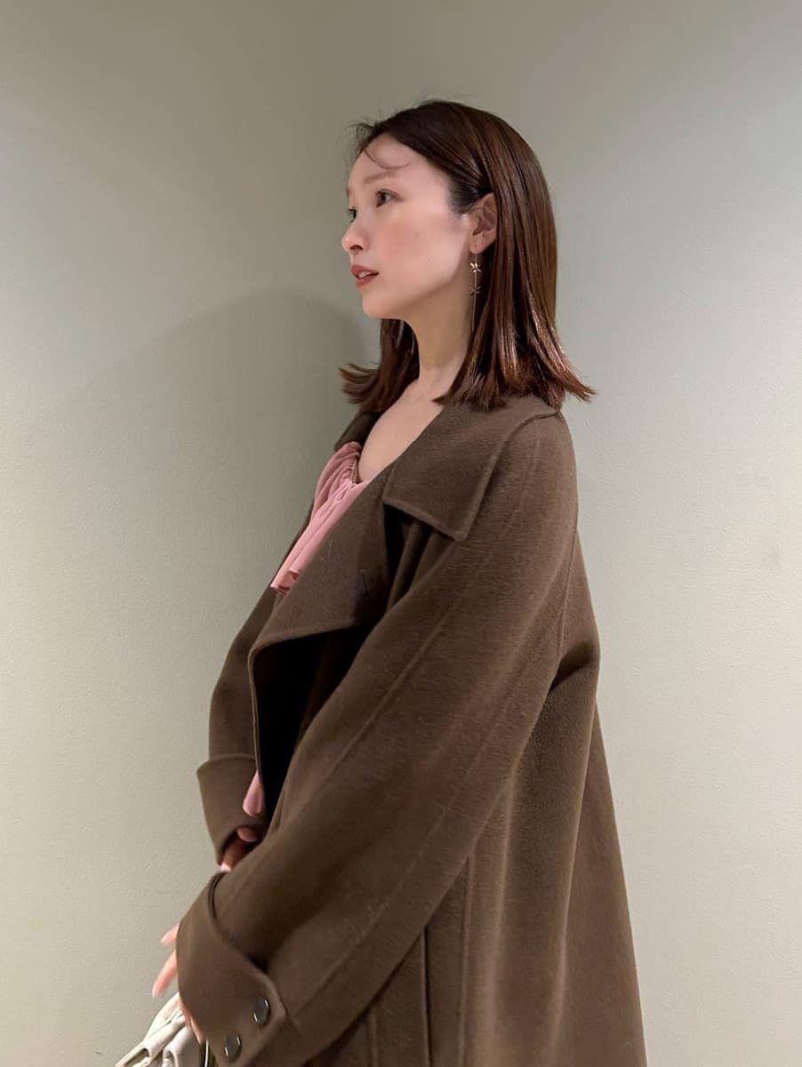 ブラウン系のブーツ、オレンジ系のワンピース、ホワイト系のボストンバッグを着用したレディースの冬コーディネートの5枚目の写真