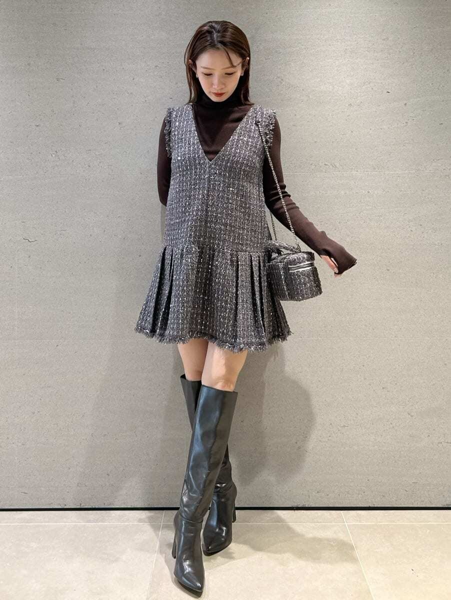 グレー系のワンピース、ブラウン系のニット/セーター、グレー系のハンドバッグを着用したレディースの秋コーディネートの4枚目の写真