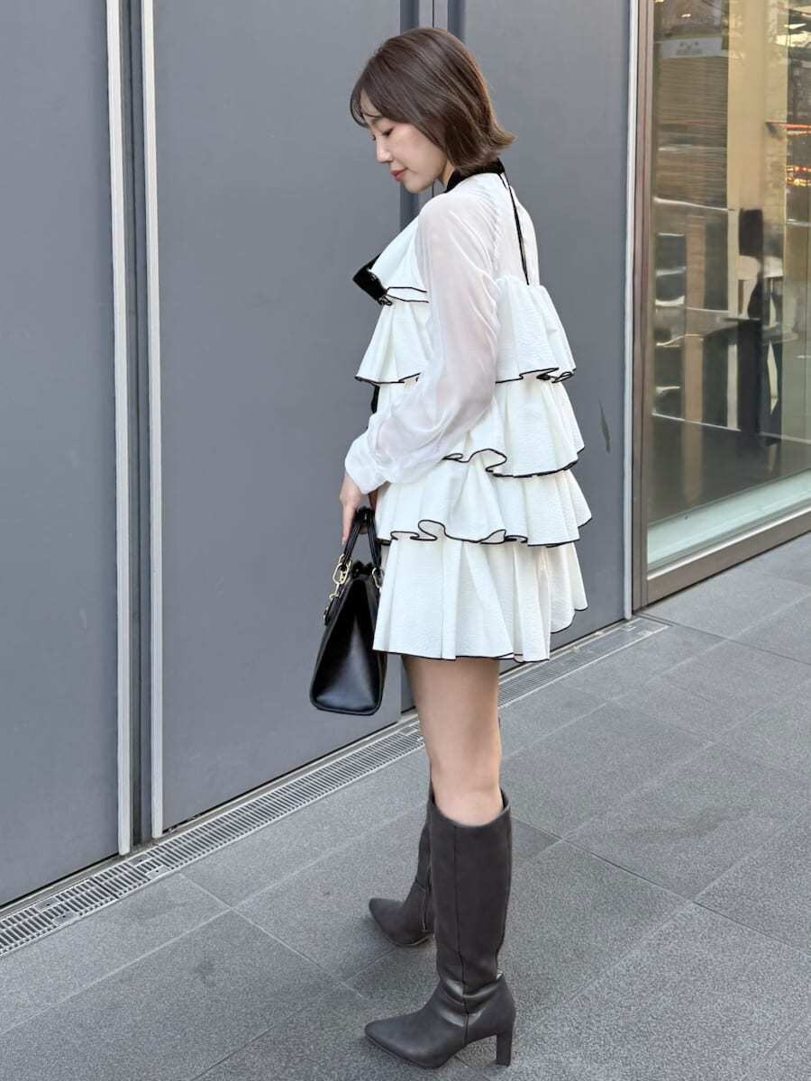ホワイト系のドレス、ブラック系のハンドバッグを着用したレディースの冬コーディネートの4枚目の写真