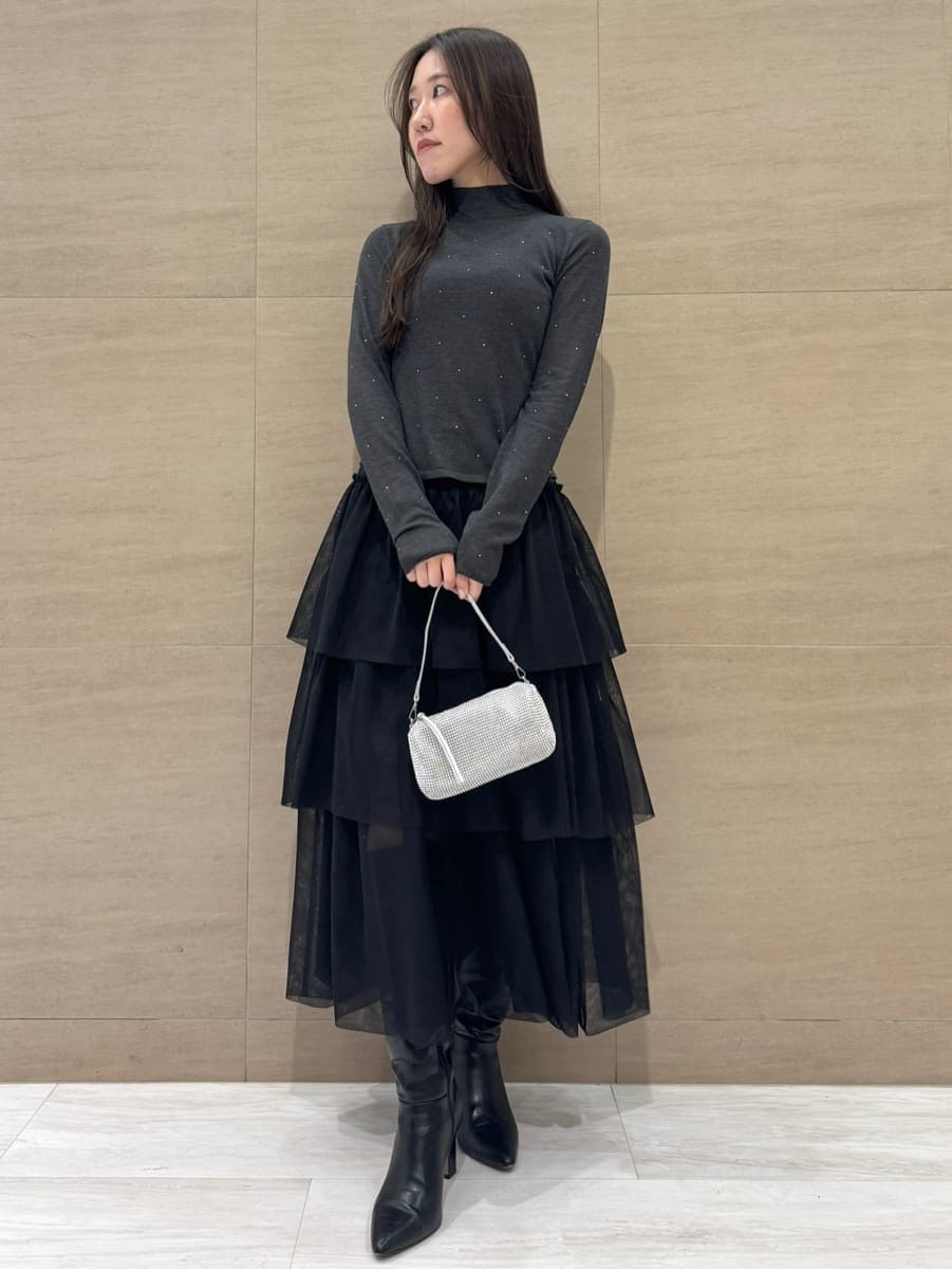 ブラック系のブーツ、ブラック系のスカート、グレー系のニット/セーターを着用したレディースの冬コーディネートの2枚目の写真