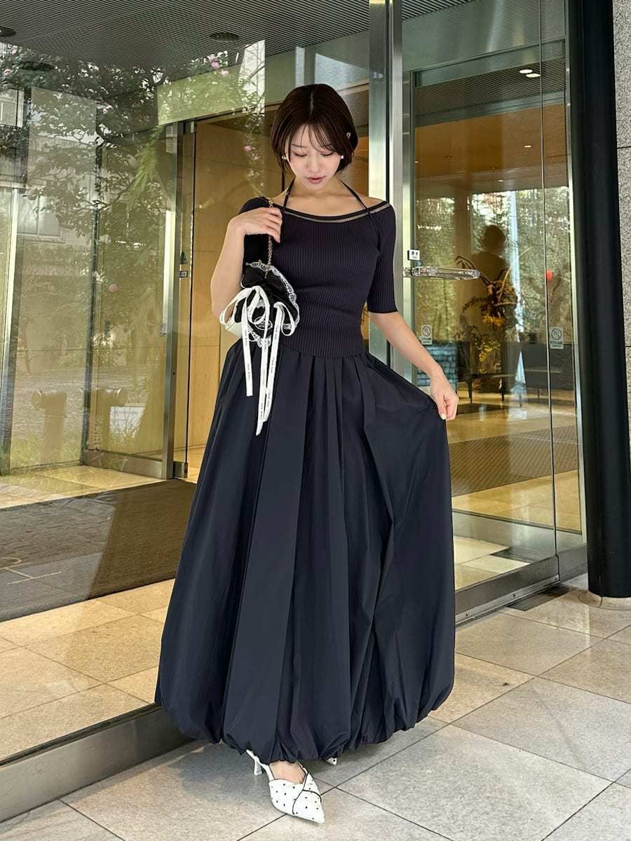 ホワイト系のショルダーバッグ、ブラック系のシュシュを着用したレディースの春コーディネートの2枚目の写真