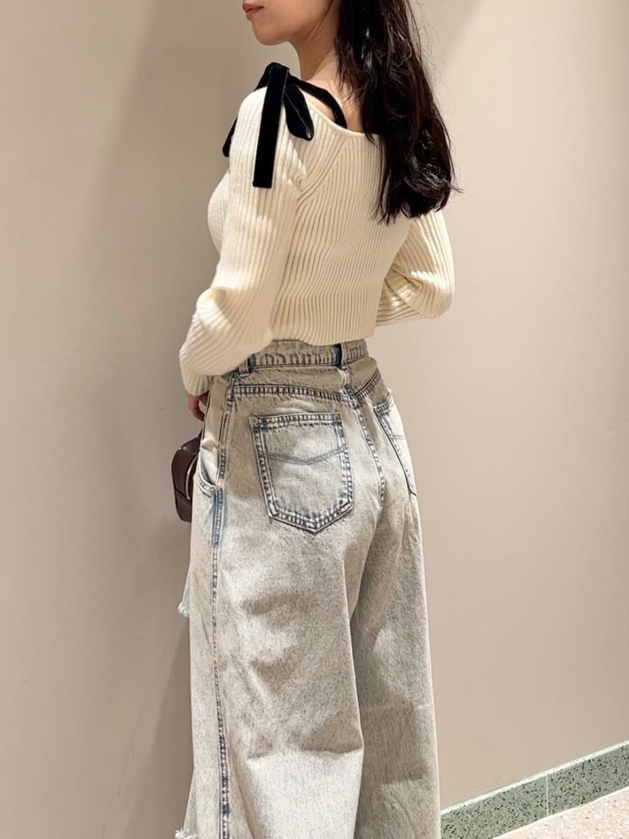 ホワイト系のニット/セーター、ブルー系のデニムパンツ、ブラウン系のボストンバッグを着用したレディースの秋コーディネートの6枚目の写真