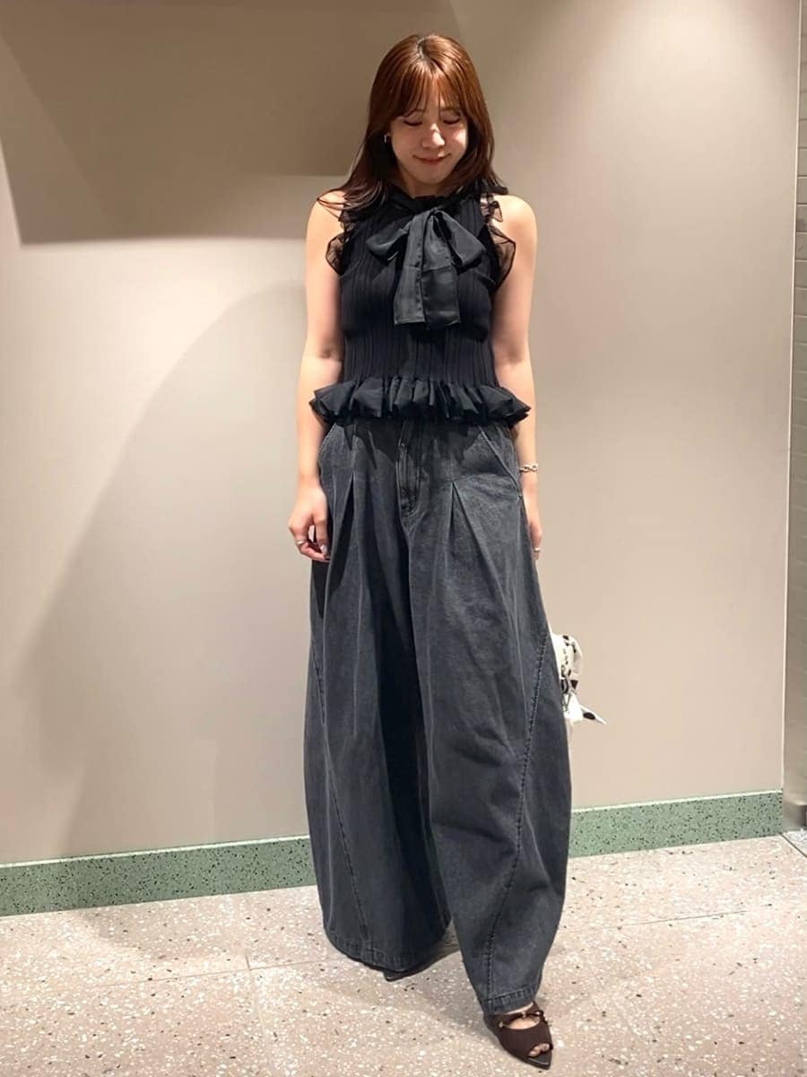 ホワイト系のショルダーバッグ、ブラック系のデニムパンツ、ブラック系のニット/セーターを着用したレディースの夏コーディネートの5枚目の写真