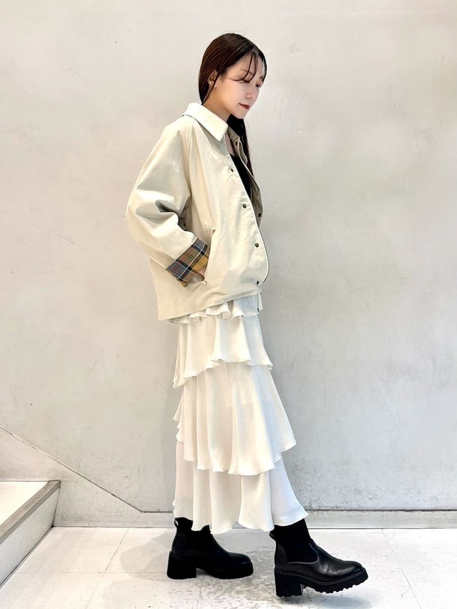 ホワイト系のブルゾン、ブラック系のニット/セーター、ホワイト系のスカートを着用したレディースの秋コーディネートの3枚目の写真