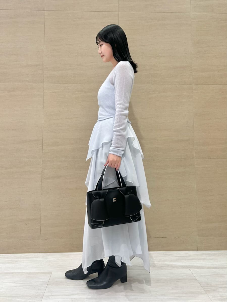 ブルー系のワンピース、ブラック系のハンドバッグを着用したレディースの冬コーディネートの2枚目の写真