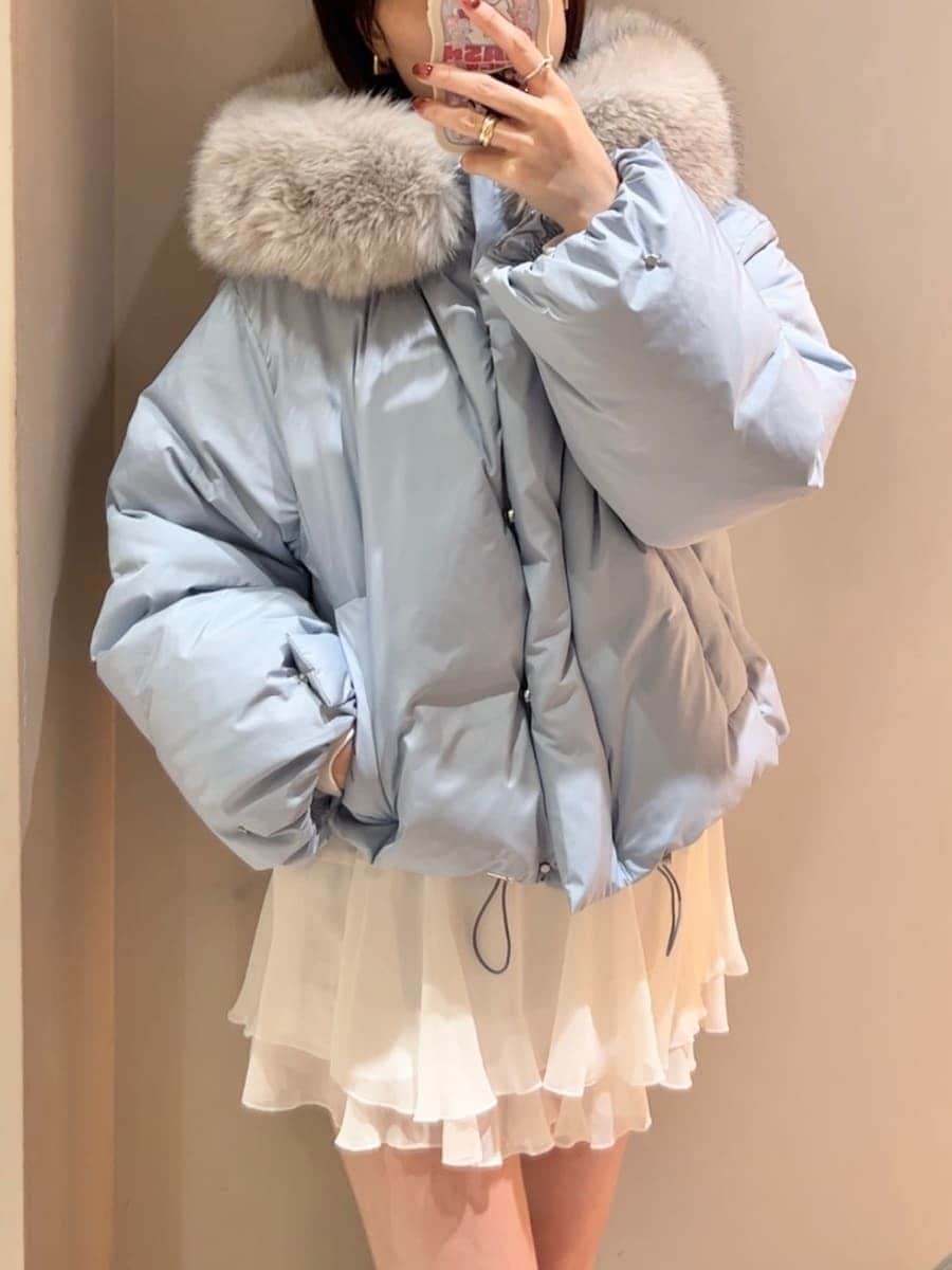 ブラック系のハンドバッグ、ブルー系のダウンジャケット/コート、ホワイト系のその他パンツを着用したレディースの秋コーディネートの9枚目の写真