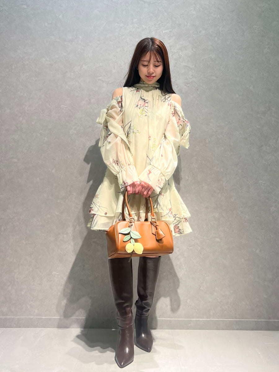 ブラウン系のブーツ、イエロー系のワンピース、イエロー系のボストンバッグを着用したレディースの冬コーディネートの2枚目の写真