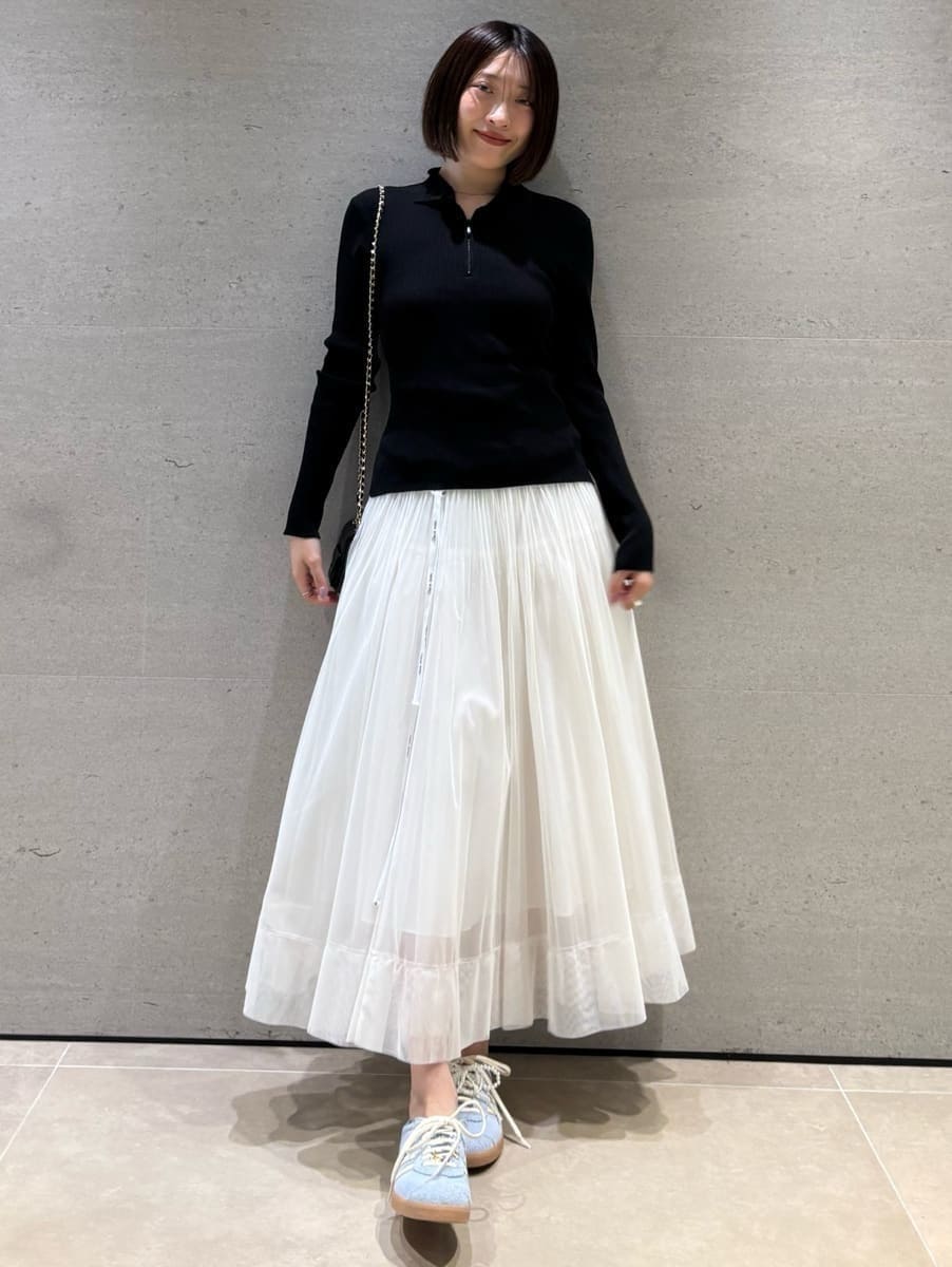 ブラック系のニット/セーター、ホワイト系のスカートを着用したレディースの秋コーディネートの2枚目の写真