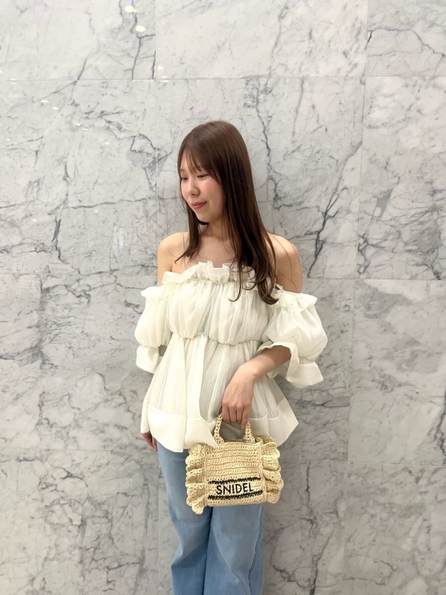 ブルー系のデニムパンツ、ホワイト系のその他トップス、ベージュ系のショルダーバッグを着用したレディースの春コーディネートの4枚目の写真
