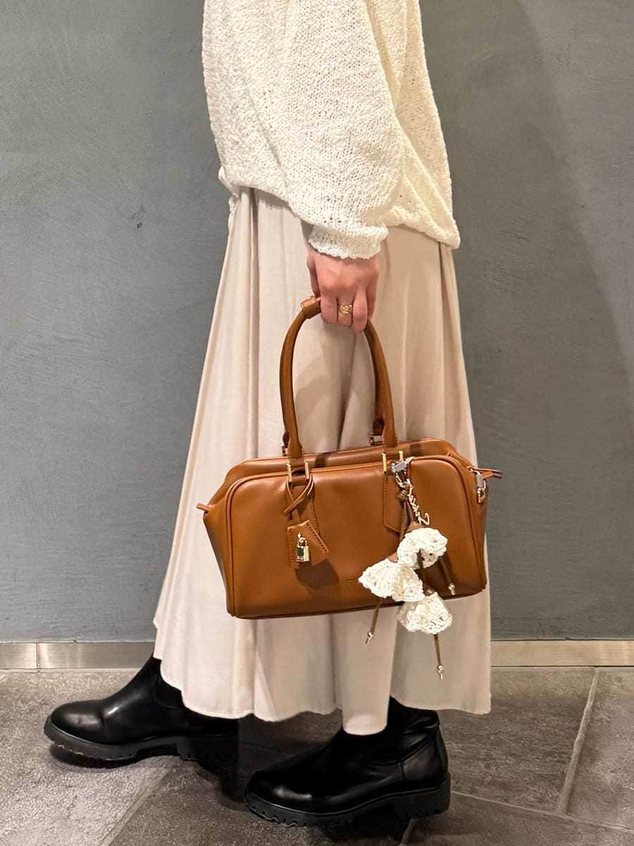 ホワイト系のワンピース、イエロー系のボストンバッグを着用したレディースの冬コーディネートの10枚目の写真