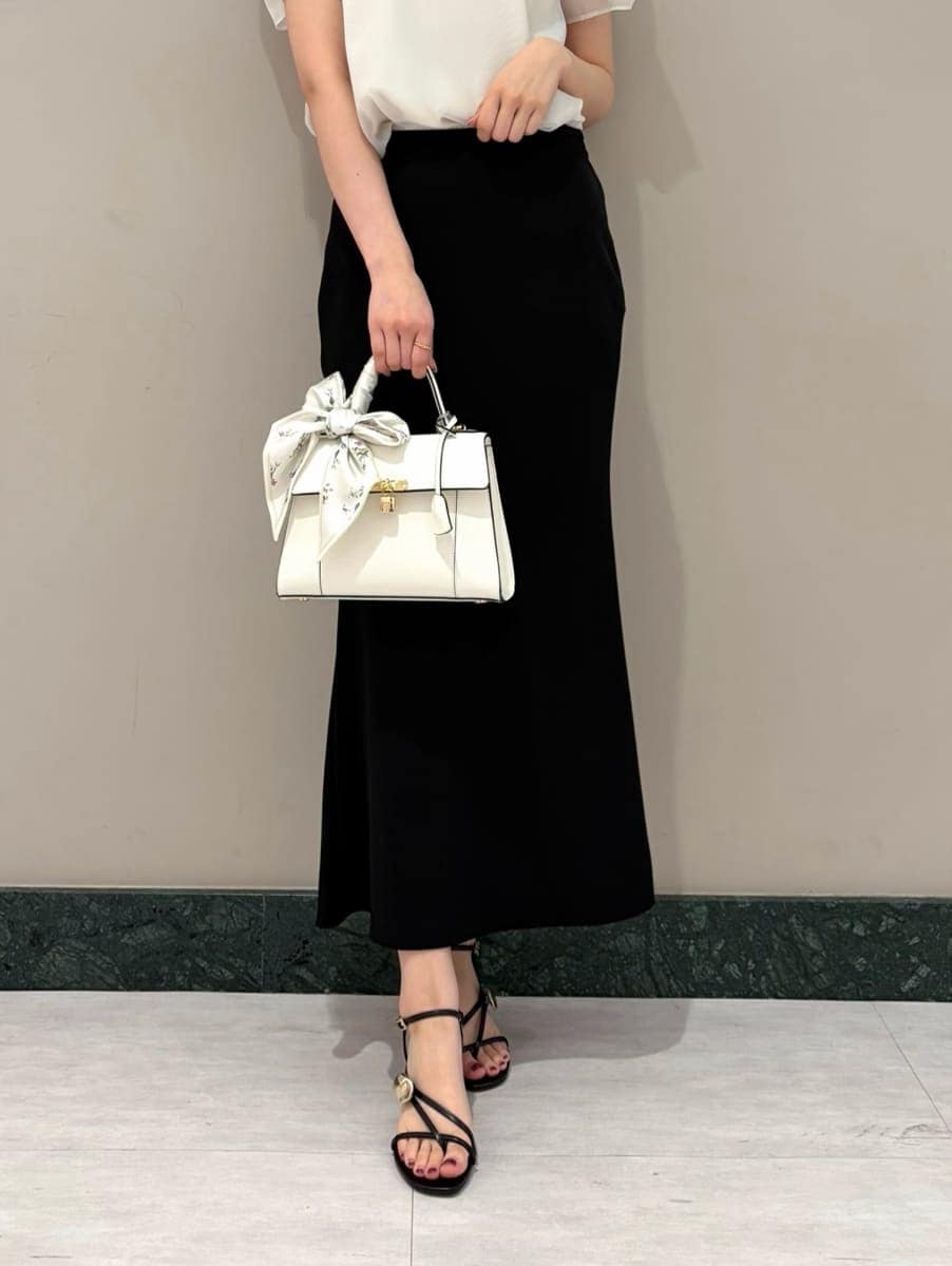 ブラック系のスカート、ホワイト系のシャツ/ブラウス、ホワイト系のハンドバッグを着用したレディースの春コーディネートの4枚目の写真