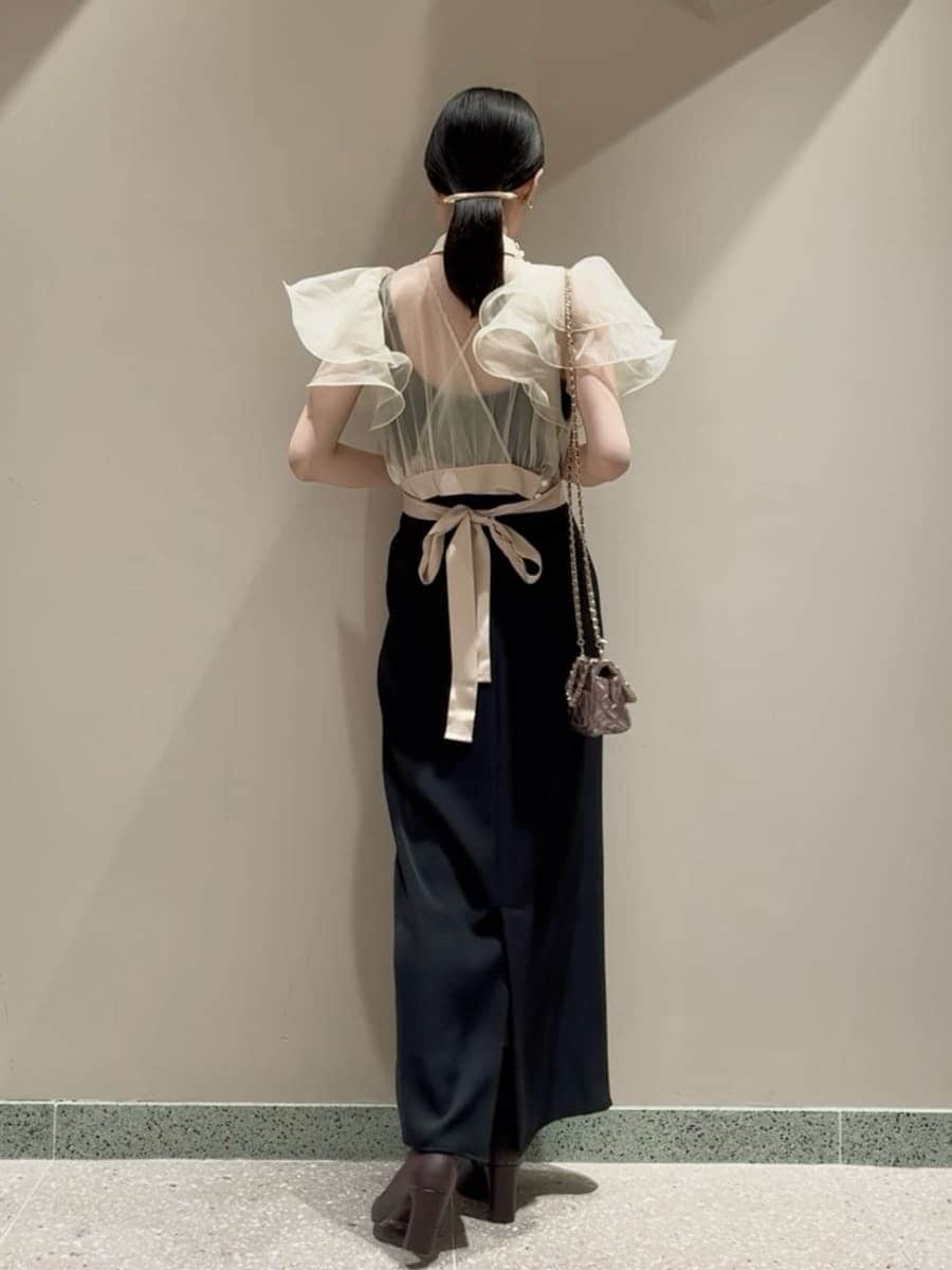 レッド系のブーツ、パープル系のショルダーバッグ、ブラック系のワンピースを着用したレディースの冬コーディネートの3枚目の写真