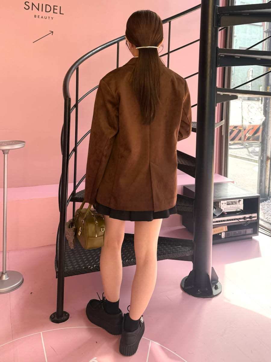 ブラウン系のテーラードジャケット、グレー系のニット/セーター、ブラック系のその他パンツを着用したレディースの秋コーディネートの3枚目の写真