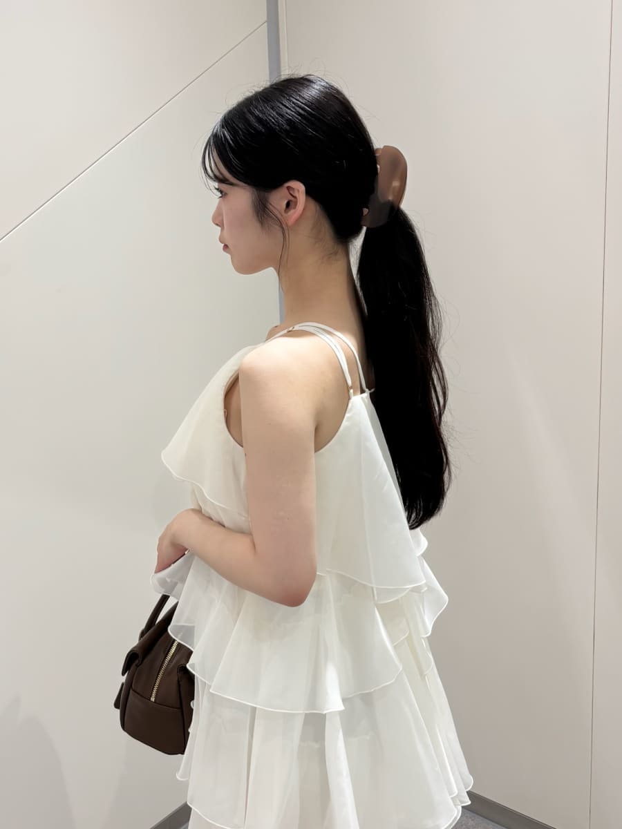 イエロー系のボストンバッグ、ホワイト系のドレス、ホワイト系のサンダルを着用したレディースの夏コーディネートの3枚目の写真