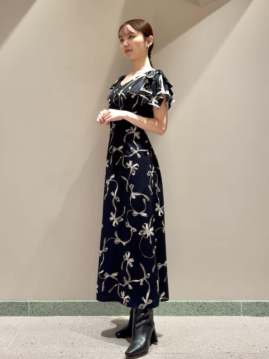 ブルー系のワンピース、ブラック系のブーツ、ブラック系のショルダーバッグを着用したレディースの秋コーディネートの2枚目の写真