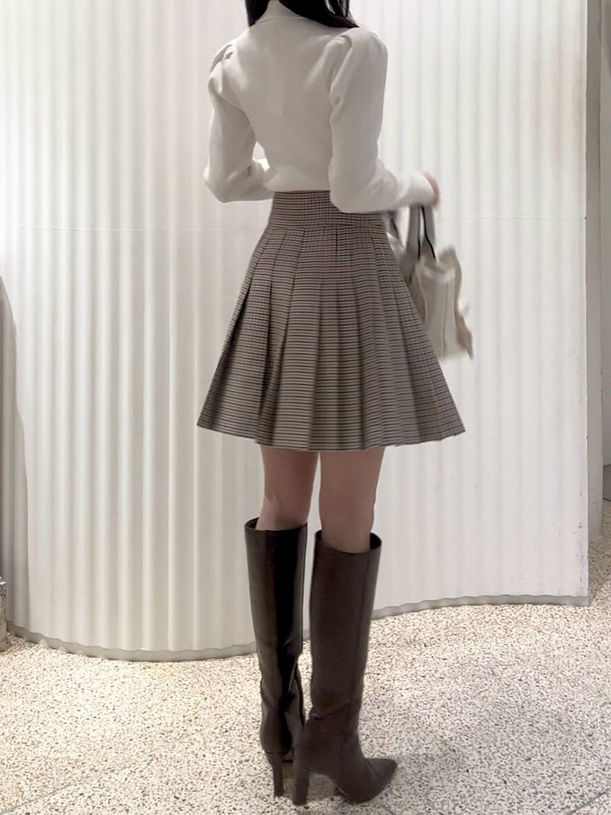 ベージュ系のスカート、ブラウン系のブーツ、ホワイト系のダウンジャケット/コートを着用したレディースの秋コーディネートの6枚目の写真