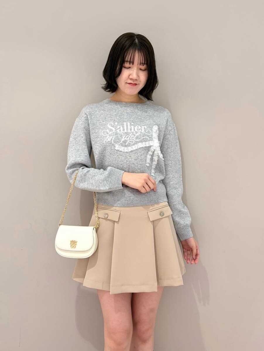 ベージュ系のスカート、グレー系のニット/セーター、ホワイト系のショルダーバッグを着用したレディースの冬コーディネートの4枚目の写真