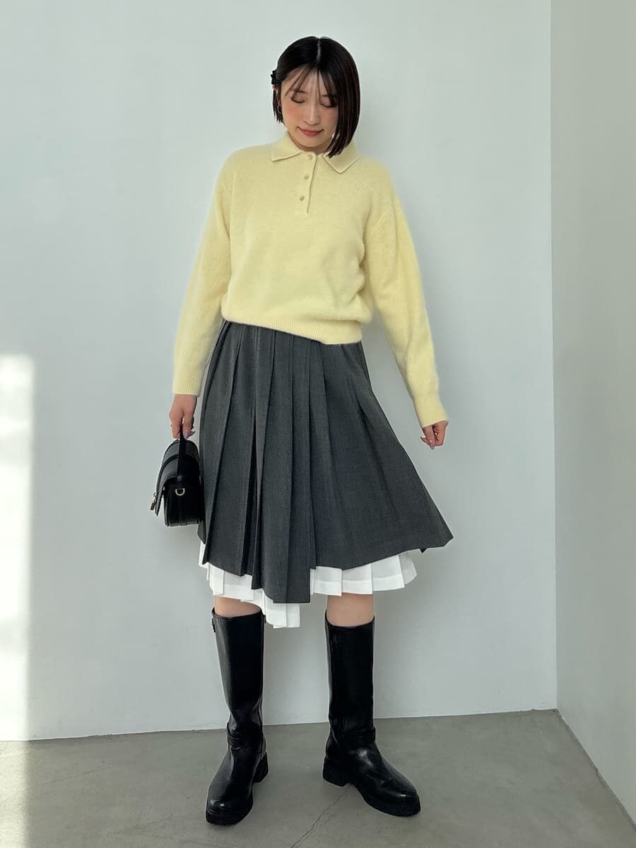 ブラック系のブーツ、ブラック系のハンドバッグ、イエロー系のニット/セーターを着用したレディースの秋コーディネートの2枚目の写真