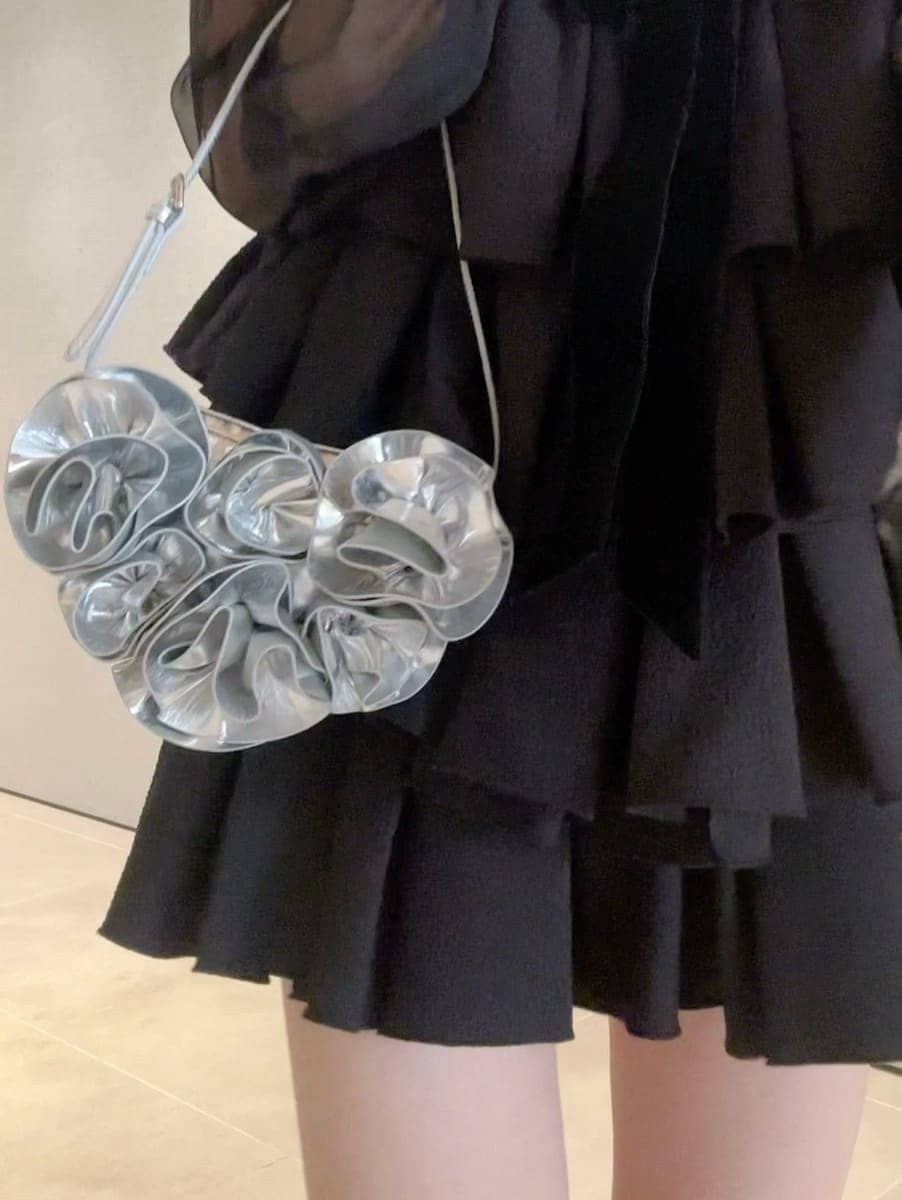 ブラック系のドレス、シルバー系のスニーカーを着用したレディースの冬コーディネートの2枚目の写真