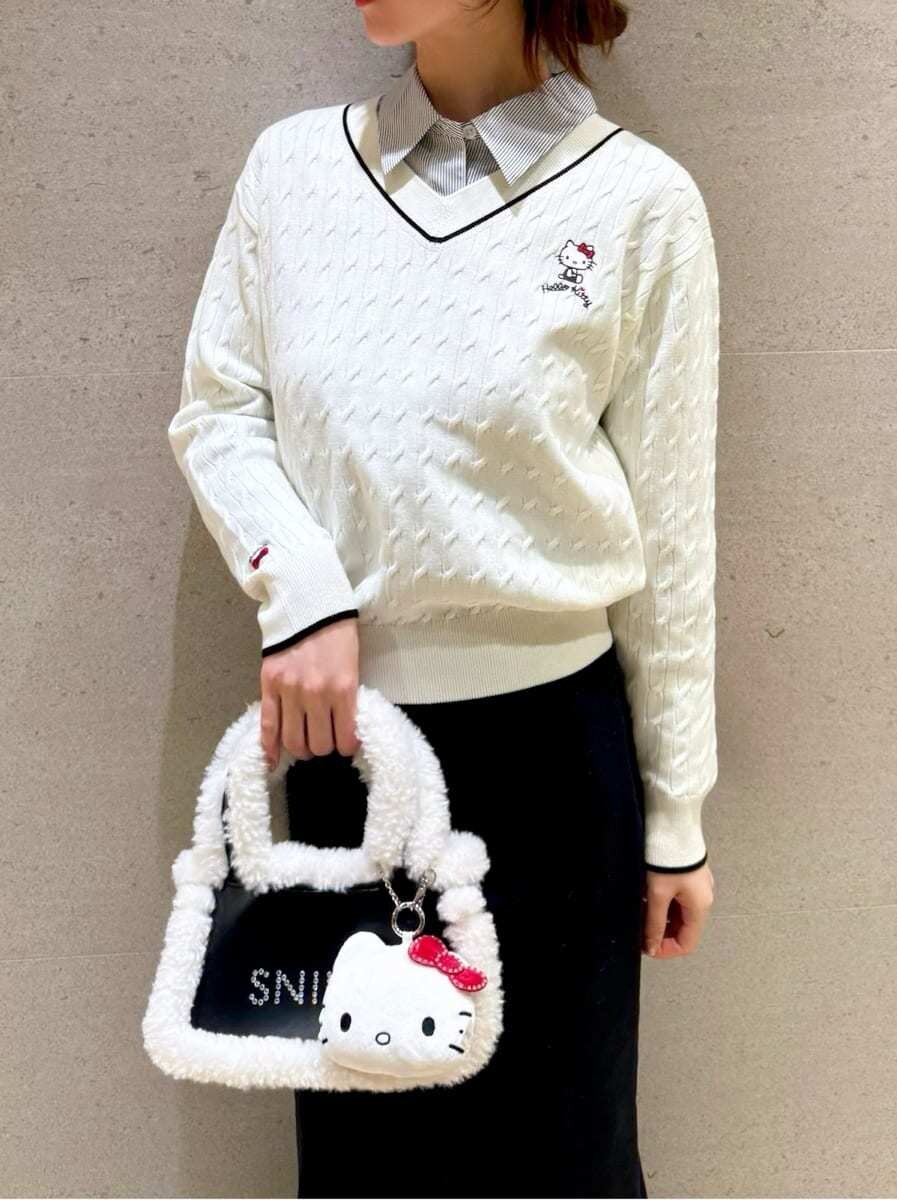 ホワイト系のニット/セーター、ブラック系のハンドバッグ、ブルー系のシャツ/ブラウスを着用したレディースの秋コーディネートの3枚目の写真