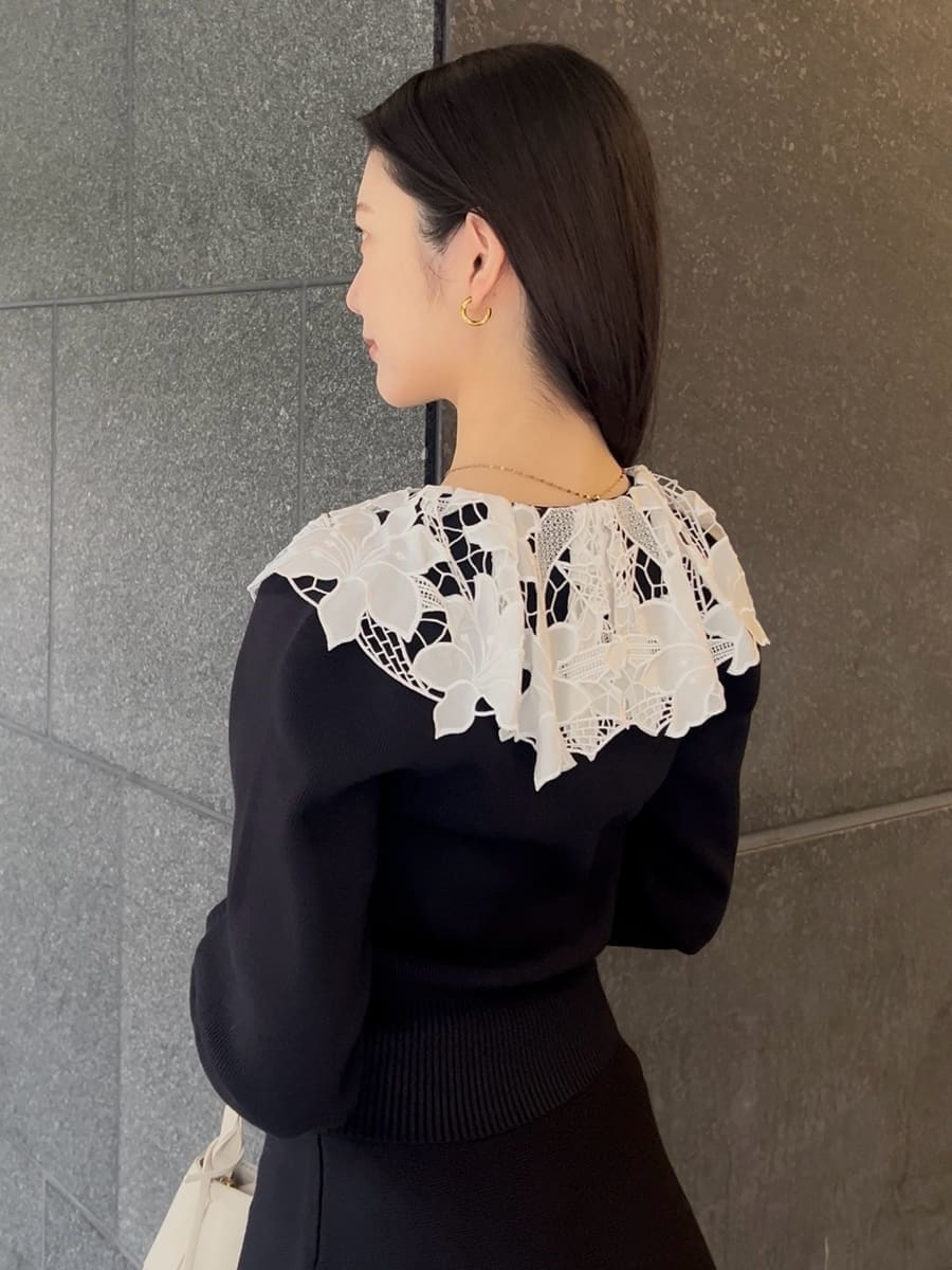 ブラック系のブーツ、ブラック系のワンピース、ホワイト系のハンドバッグを着用したレディースの冬コーディネートの5枚目の写真