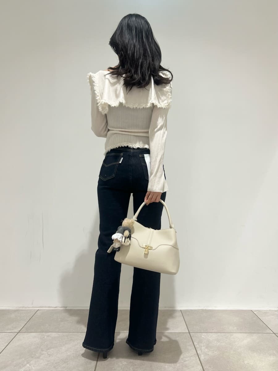 ブラック系のブーツ、ブルー系のその他パンツ、ホワイト系のニット/セーターを着用したレディースの冬コーディネートの3枚目の写真