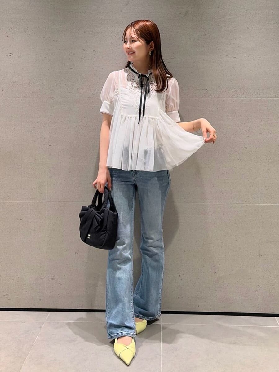 ブルー系のデニムパンツ、イエロー系のパンプス、その他のシャツ/ブラウスを着用したレディースの春コーディネートの2枚目の写真