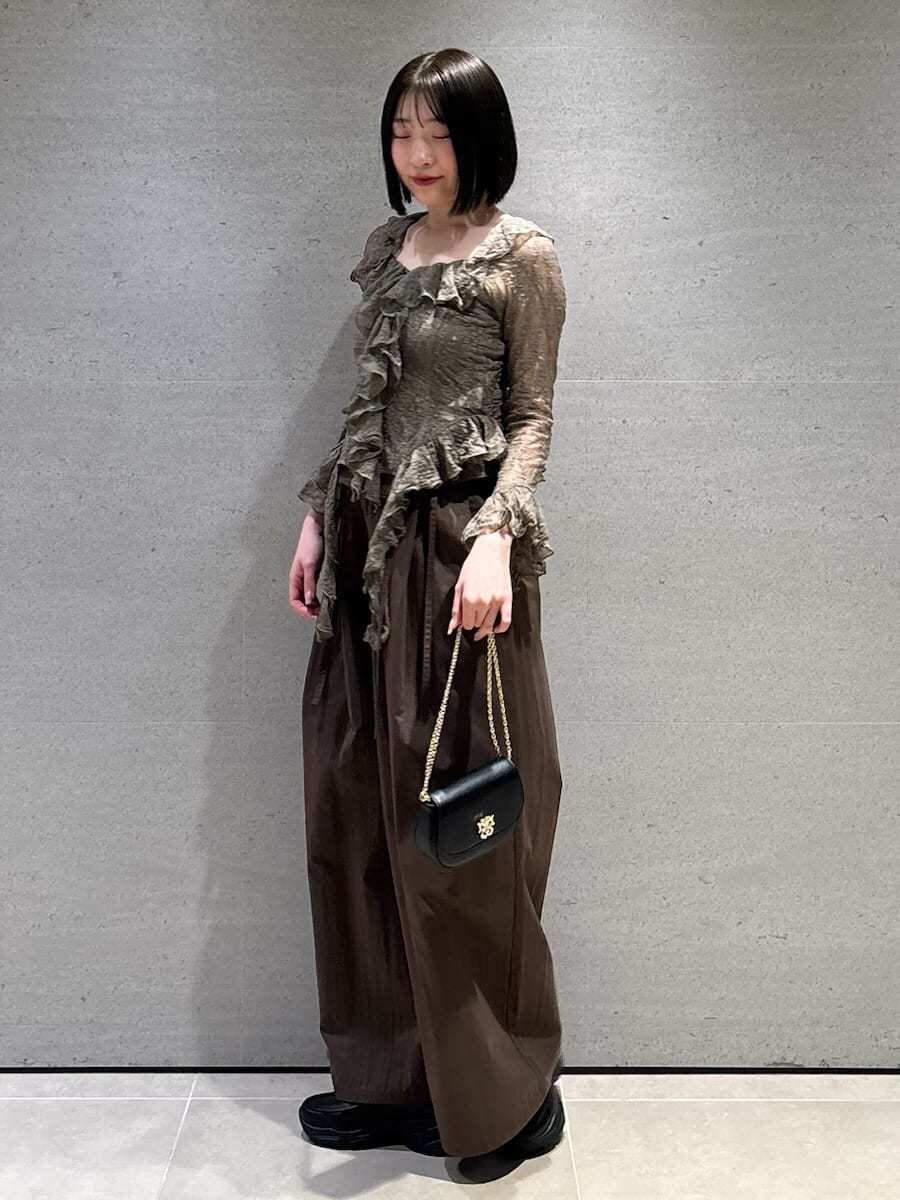ブラウン系のその他パンツ、グリーン系のTシャツ/カットソー、ブラック系のショルダーバッグを着用したレディースの冬コーディネートの5枚目の写真