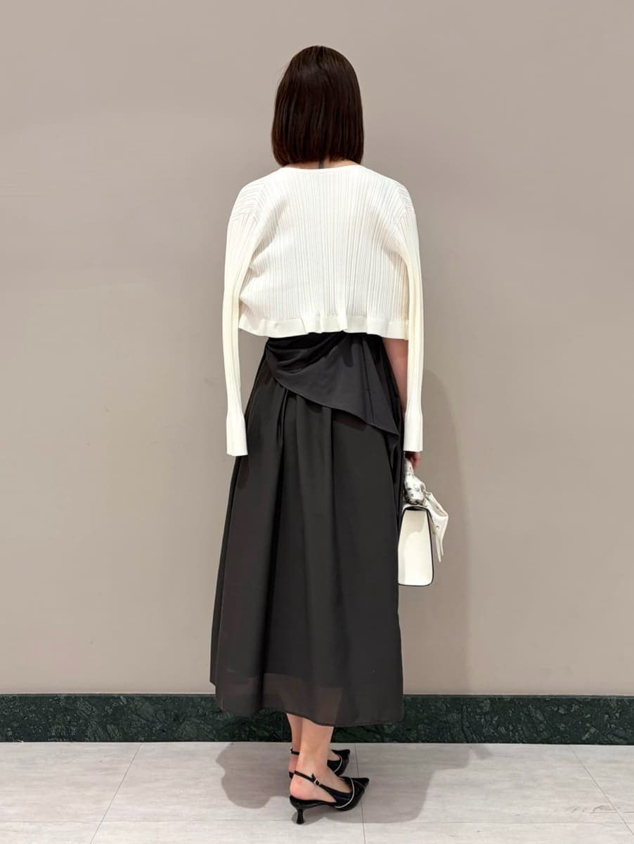 グレー系のワンピース、ホワイト系のカーディガン/ボレロ、ブラック系のパンプスを着用したレディースの春コーディネートの5枚目の写真