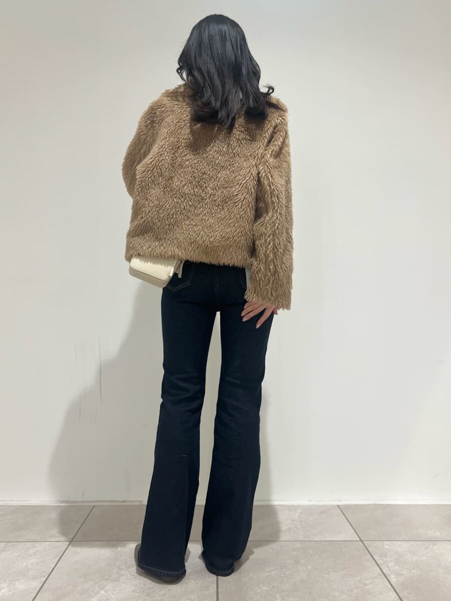 ブルー系のその他パンツ、イエロー系のムートンコート、ホワイト系のニット/セーターを着用したレディースの冬コーディネートの3枚目の写真