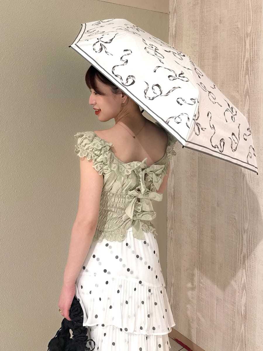 その他のスカート、グリーン系のシャツ/ブラウス、ホワイト系の折りたたみ傘を着用したレディースの春コーディネートの6枚目の写真