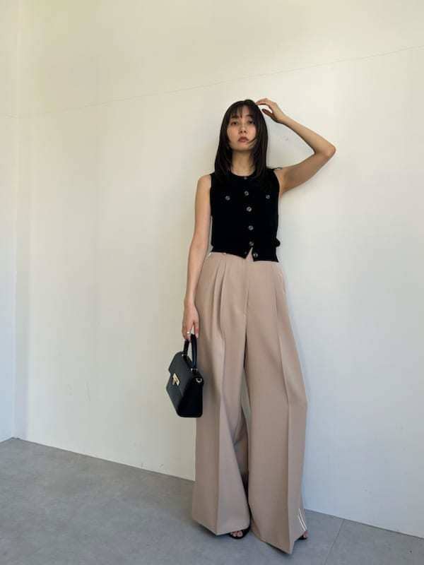 ブラック系のニット/セーター、ベージュ系のその他パンツ、ブラック系のショルダーバッグを着用したレディースの春コーディネートの2枚目の写真