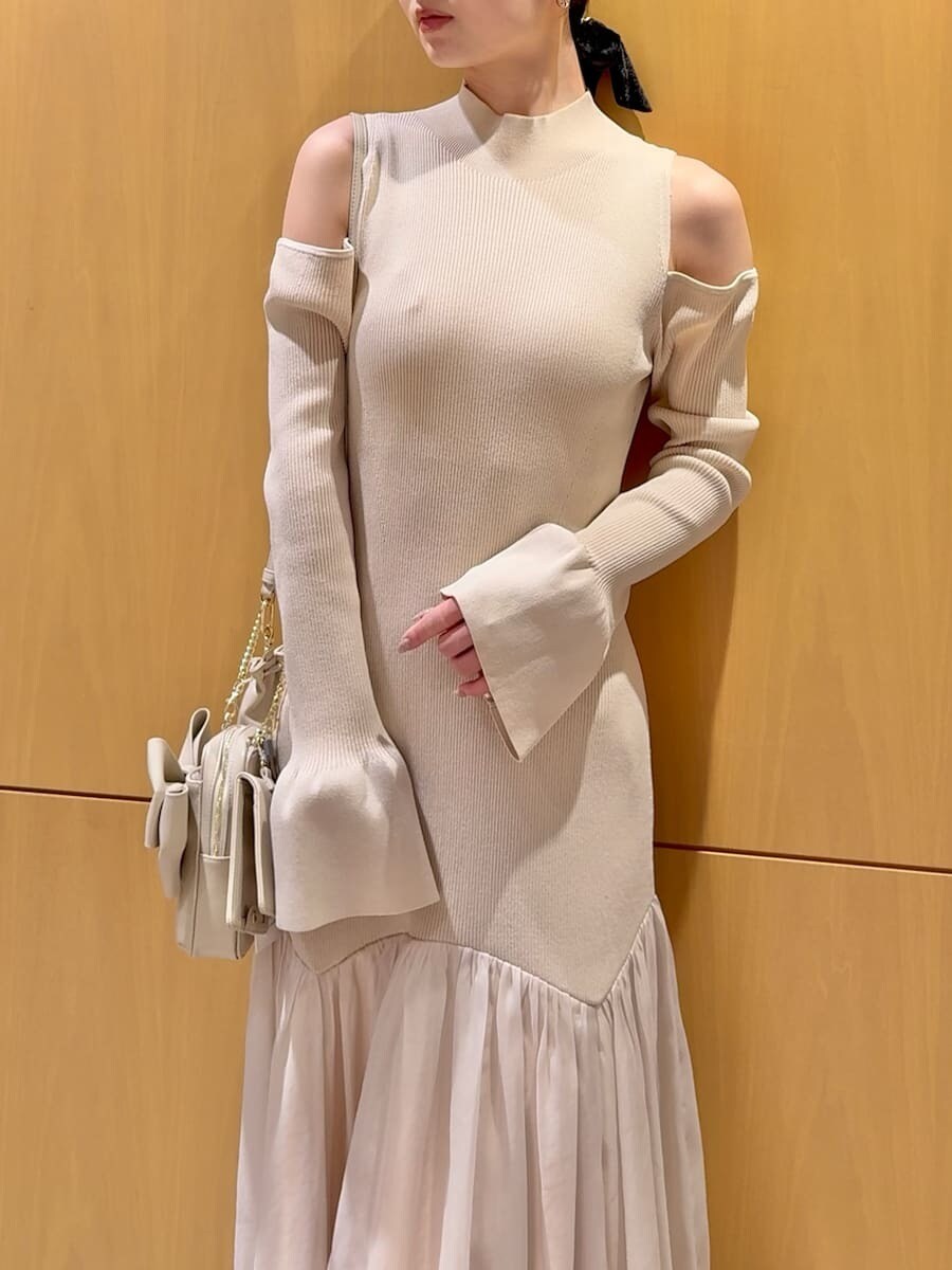 グレー系のチェスターコート、ホワイト系のワンピース、ブラック系のブーツを着用したレディースの冬コーディネートの8枚目の写真