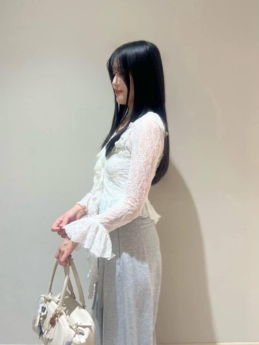 ブラック系のブーツ、ホワイト系のトレンチコート、グレー系のその他パンツを着用したレディースの冬コーディネートの10枚目の写真