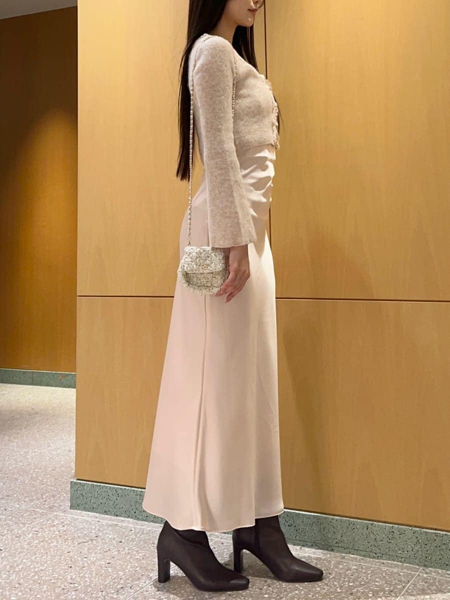 レッド系のブーツ、ホワイト系のショルダーバッグ、ピンク系のワンピースを着用したレディースの秋コーディネートの4枚目の写真