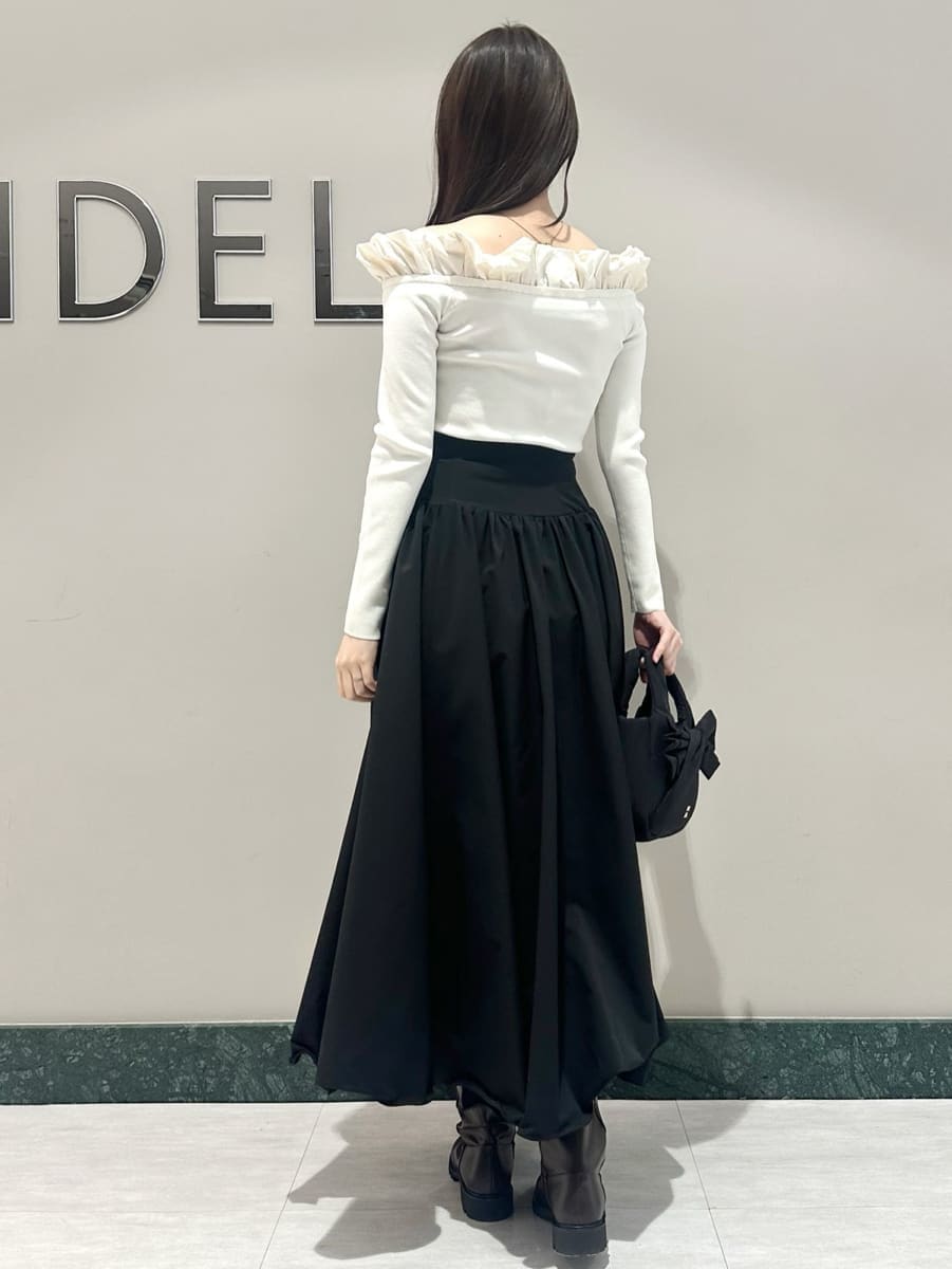 ブラック系のスカート、ホワイト系のニット/セーターを着用したレディースの冬コーディネートの5枚目の写真