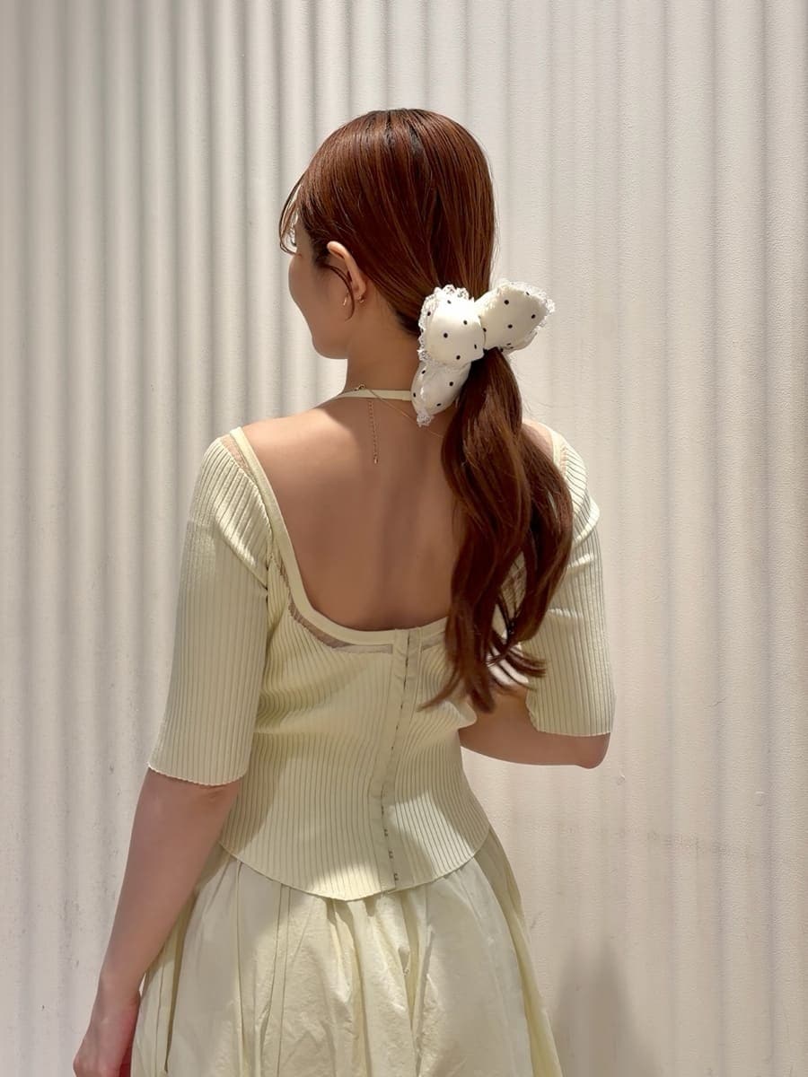 ホワイト系のハンドバッグ、ホワイト系のパンプス、ゴールド系のイヤリングを着用したレディースの春コーディネートの8枚目の写真