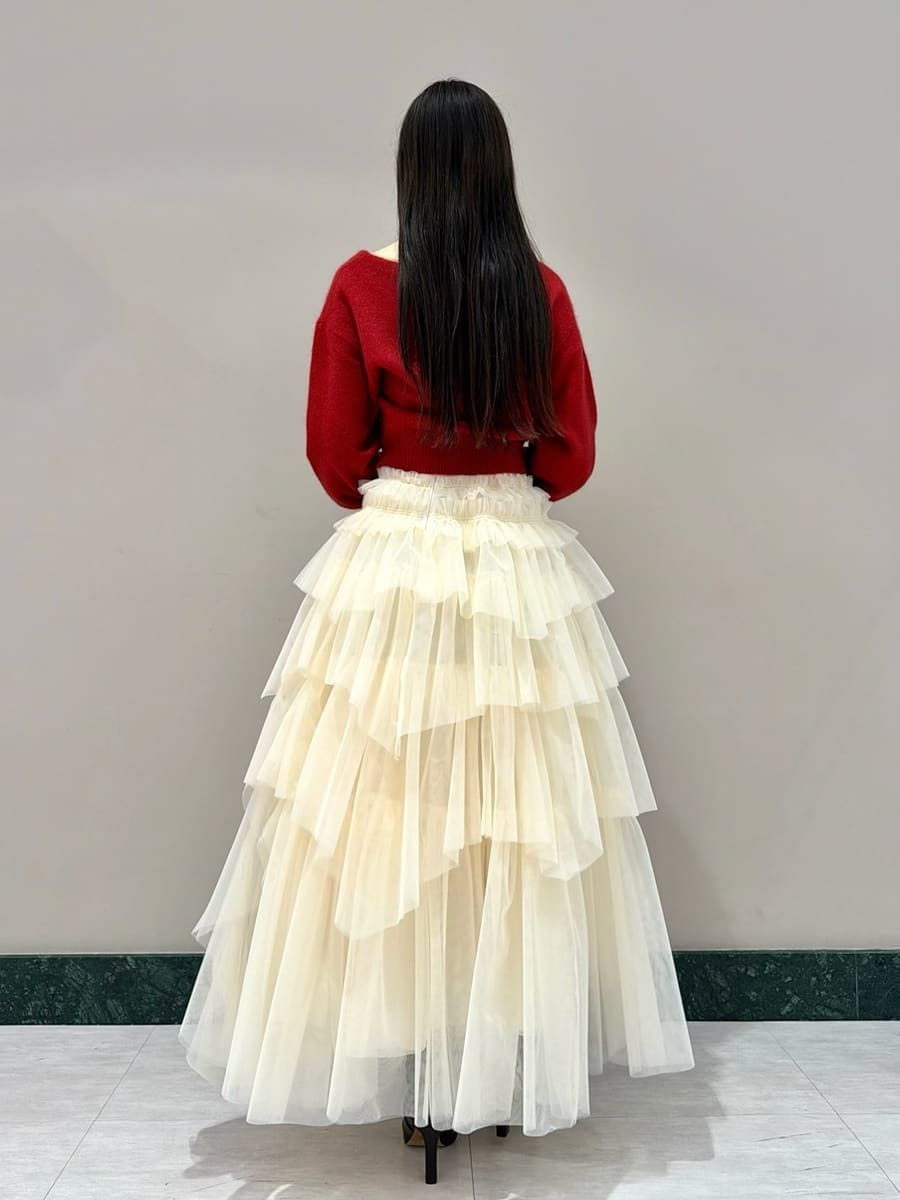 ブラウン系のブーツ、レッド系のカーディガン/ボレロ、ブラウン系のハンドバッグを着用したレディースの冬コーディネートの3枚目の写真