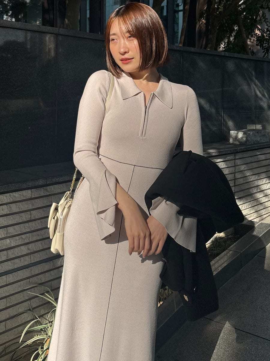 ブラック系のピーコート、ホワイト系のワンピース、ホワイト系のショルダーバッグを着用したレディースの冬コーディネートの5枚目の写真