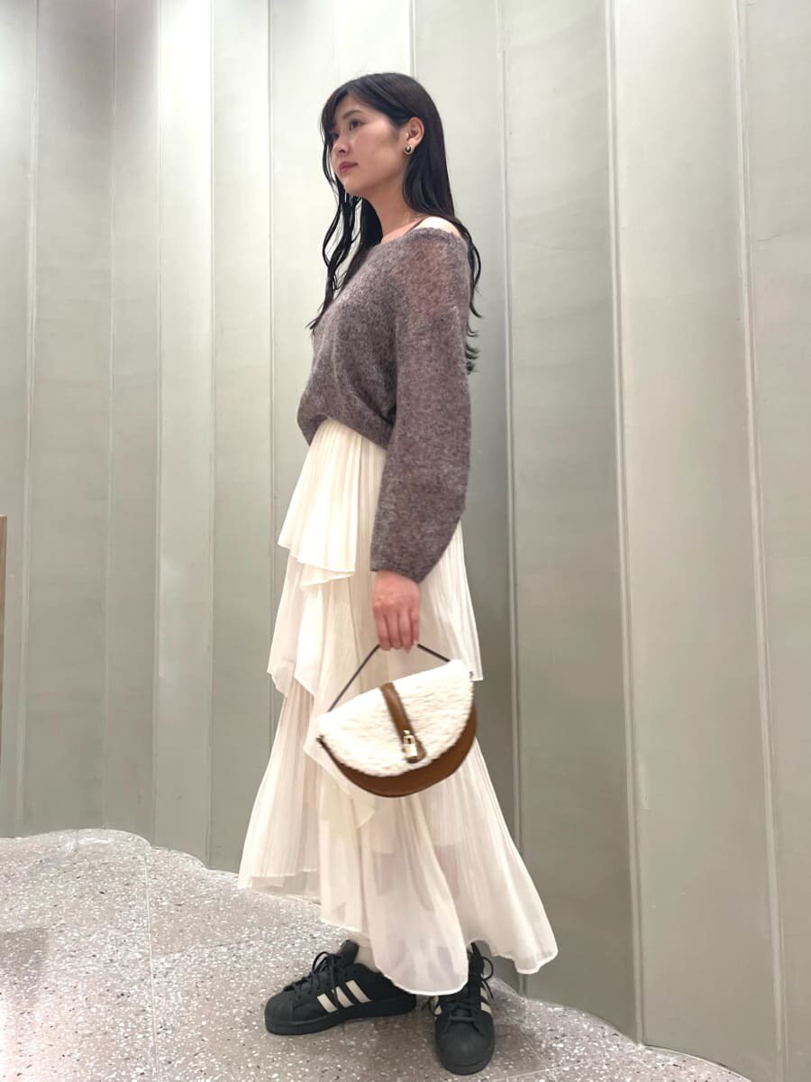 ブラウン系のニット/セーター、ホワイト系のスカート、イエロー系のハンドバッグを着用したレディースの秋コーディネートの2枚目の写真