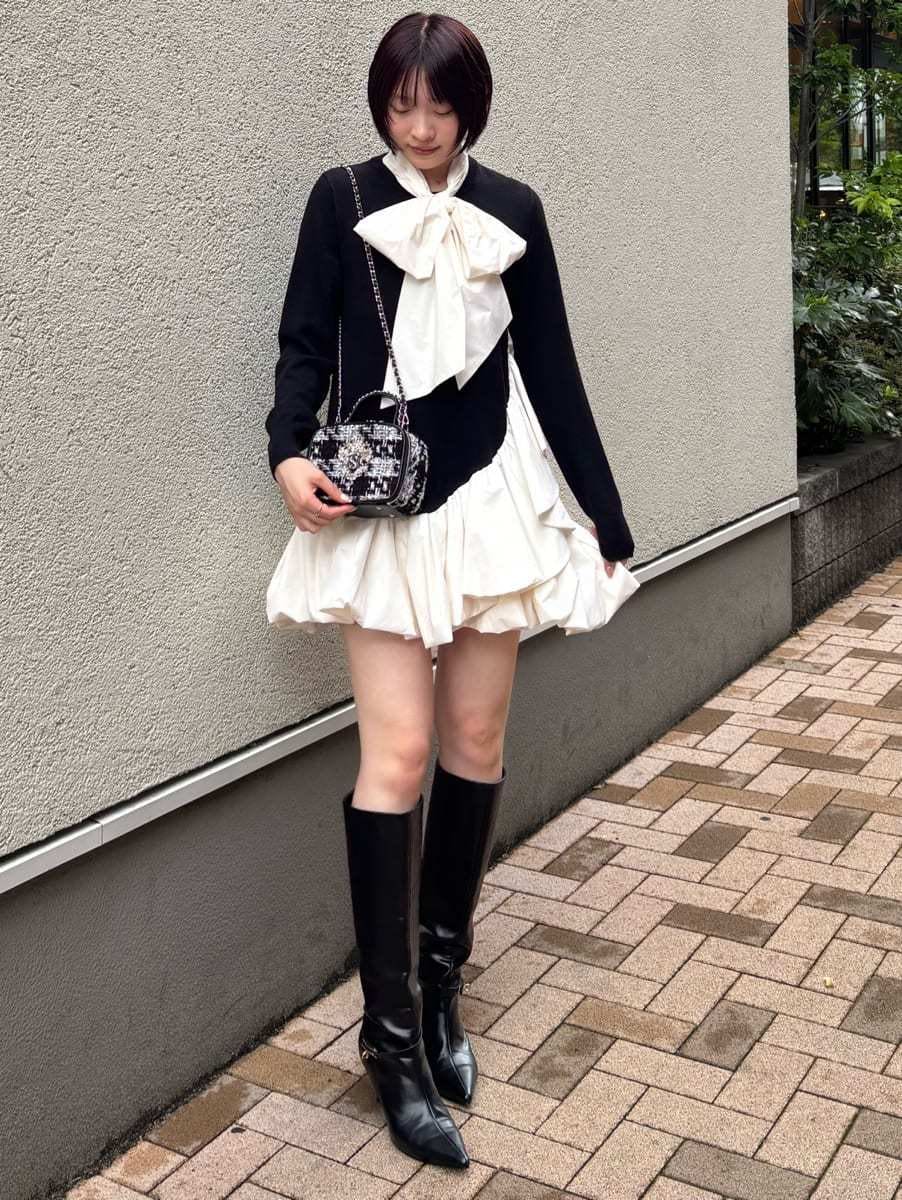 ブラック系のワンピース、ブラック系のブーツ、その他のショルダーバッグを着用したレディースの秋コーディネートの3枚目の写真