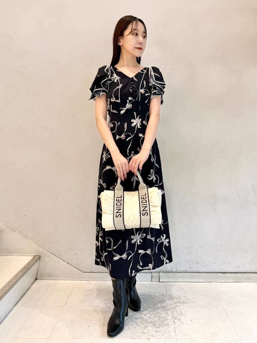 ブルー系のワンピース、ベージュ系のカーディガン/ボレロ、ブラック系のブーツを着用したレディースの秋コーディネートの5枚目の写真